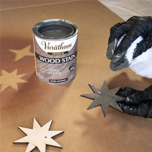 Applying Varathane wood stain to wood pieces with a rag.