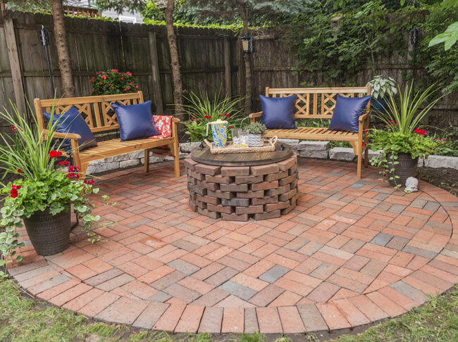 Clean brick patio with fire pit and benches.