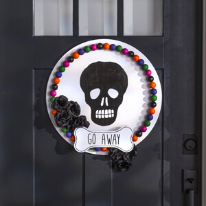 Black skull painted on a round white sign. 