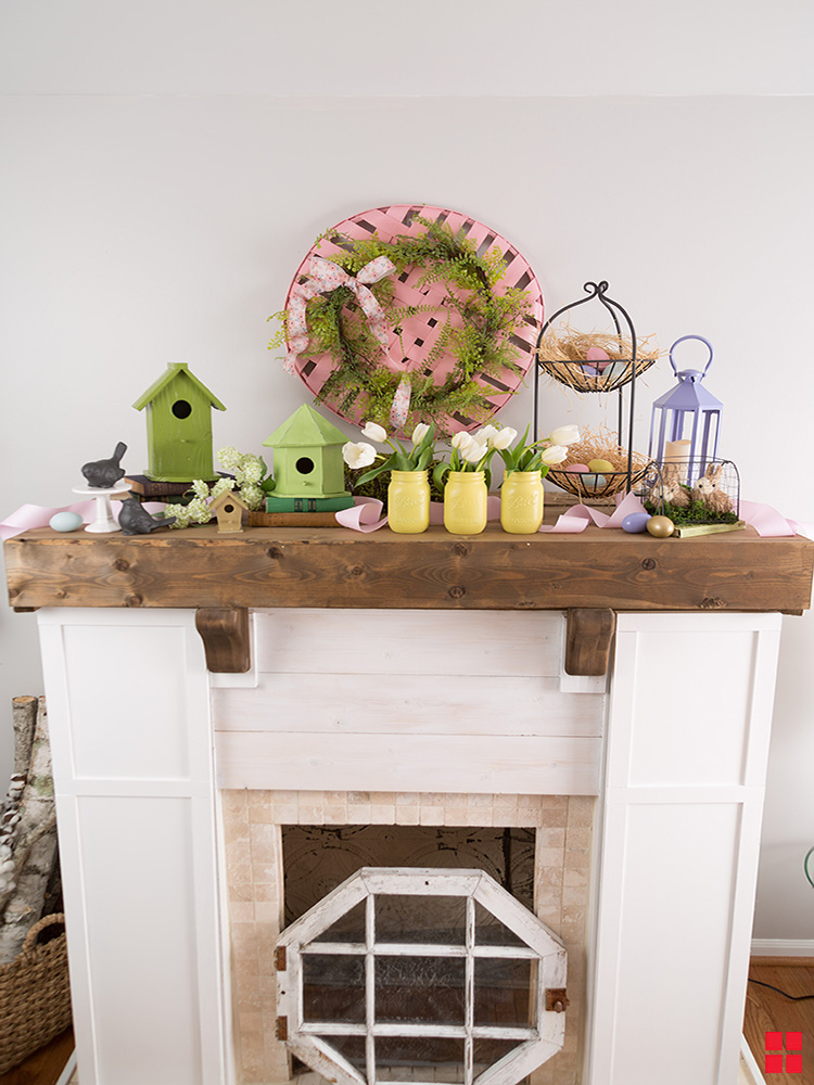 Painted birdhouses, easter eggs and jars on a mantle.