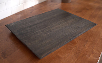 Dark brown wood charcuterie board with nothing on it.
