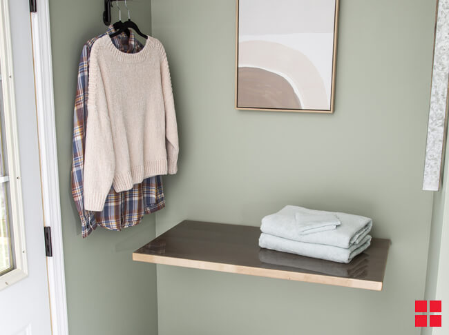 Folding Shelf Open On The Wall With Folded Towels On It