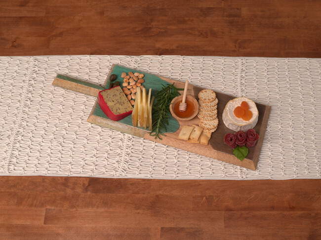 Charcuterie board with epoxy resin coating filled with snacks on a table.