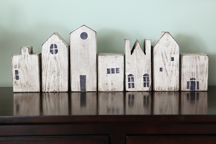 Wooden blocks shaped to buildings, stained white and painted with details to look like houses