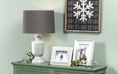 Lamp and picture frames on an entryway table.