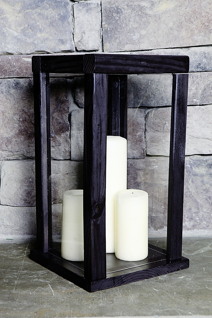 Wooden rectangular box frame painted black with candles positioned inside