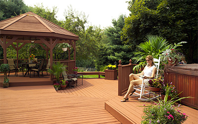 Woman sitting in a rocking chair on a newly stained wood deck.