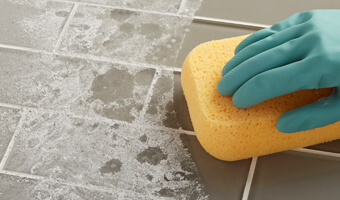Using a sponge to clean tile.