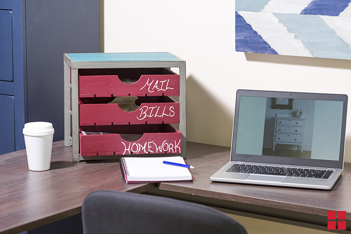 Small desktop organizer with drawers painted with red chalkboard paint and labeled with chalk