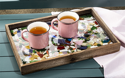 Two coffee cups on top of epoxy resin covered mosaic serving tray.