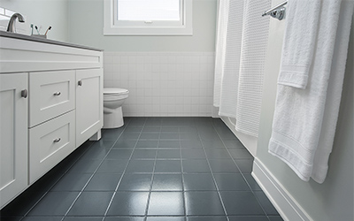 Bathroom with a white vanity and dark gray tile floor and grout. 