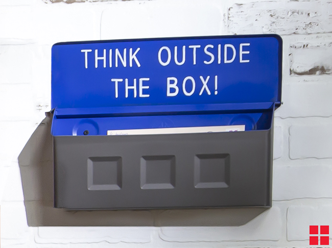 Wall mounted mailbox with “think outside the box” painted inside the cover.