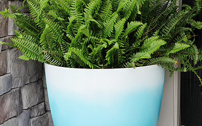 Large blue and white ombre painted planter on a front porch. 