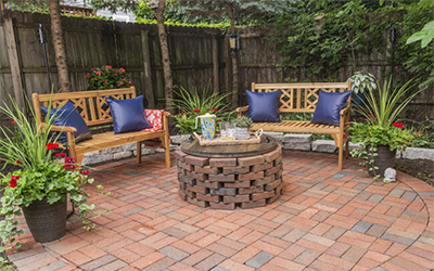 Clean brick patio with fire pit and benches.